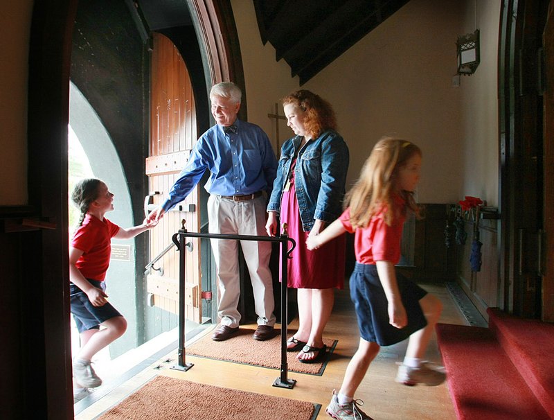 Fred Niell, headmaster, and Ann Pollard, assistant head of school, greet Trinity Episcopal Cathedral students arriving for Wednesday chapel at the church in Little Rock. 