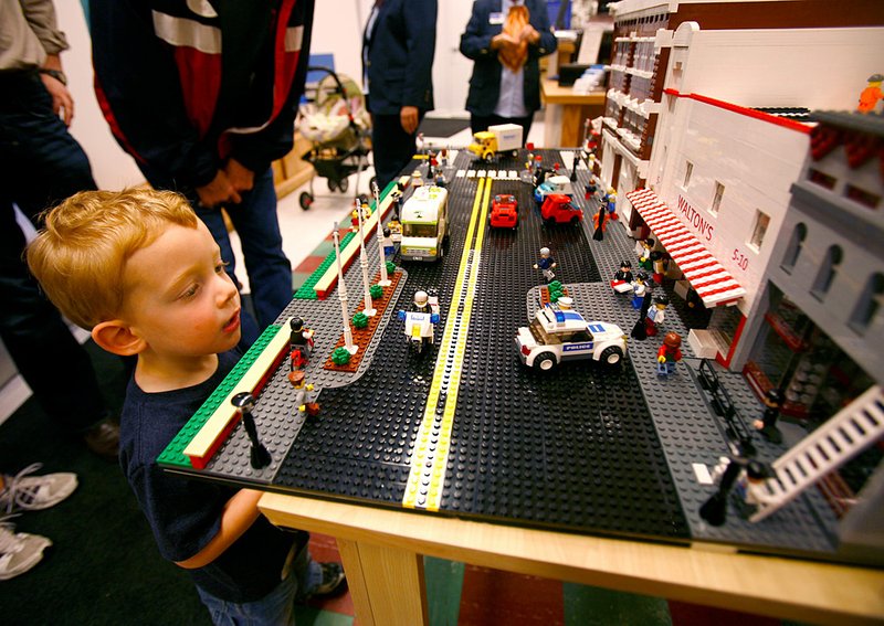  While inside the Wal-Mart Visitor Center in downtown Bentonville, Jackson Cruise, 3, of Rogers checks out a Lego replica of the center and street corner on Friday, May 20, 2011. After renovations and expansion, the center will re-open to the public today. Jackson was visiting the center with his parents, Todd and Becky Cruise, during a friends and family preview tour.