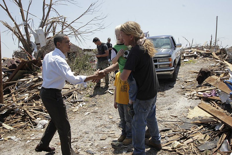  President Barack Obama, left, reaches out to residents while viewing damage from the tornado that devastated Joplin, Mo., Sunday, May 29, 2011.   