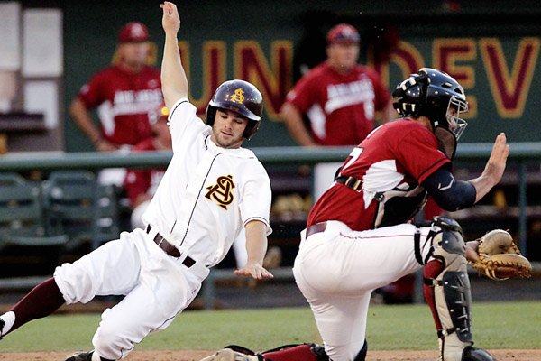 Arizona State’s Zack MacPhee scores as Arkansas catcher James McCann waits for the throw during the sixth inning of Sunday’s regional elimination game at Packard Stadium in Tempe, Ariz. The Sun Devils scored seven runs in the inning, taking a 10-0 lead, then added three more in the seventh to make it 13-1. Arkansas scored one run in the sixth and three in the seventh and was eliminated.