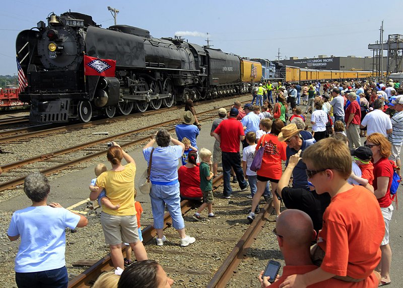  Arkansas Democrat-Gazette/BENJAMIN KRAIN 6-8-2011
Ethan Harbold, right, perches on his father's shoulder to get a better view over hundreds of train enthusiasts gathered in North Little Rock to see the arrival of the Union Pacific Steam Locomotive No. 844 on Wednesday afternoon. The train's route through Arkansas was determined by winning an online voting contest. The locomotive celebrated its 50th anniversary of special train service out of Cheyenne, Wyo., in 2010. It is the last steam locomotive built for Union Pacific Railroad and was delivered in 1944. Formerly a high-speed passenger engine, it pulled such widely known trains as the Overland Limited, Los Angeles Limited, Portland Rose and Challenger.