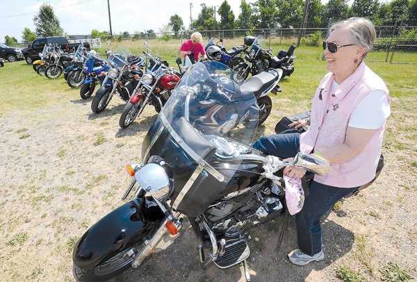 Georgia Brooks of Fayetteville, a member of the Chrome Divas, a local women-only motorcycle club, dismounts from her motorcycle Saturday after arriving at the Washington County Fairgrounds to enjoy the second Bikes, Babes & Bling motorcycle rally in Fayetteville. Go to photos.nwaonline.com to see more photos.