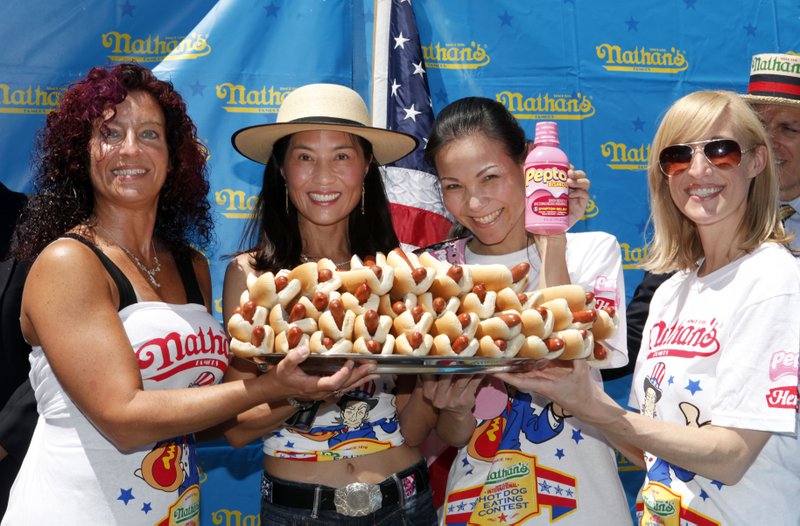 In this photo taken by AP Images for Pepto-Bismol, from left, women's championship contestants Larell Marie Mele, Juliet Lee, Sonya Thomas and Laura Leu pose together after their official weigh-in for Nathan's Famous Fourth of July International Hot Dog Eating Contest, sponsored by Pepto-Bismol, during a ceremony at City Hall Park, Friday, July 1, 2011 in New York.