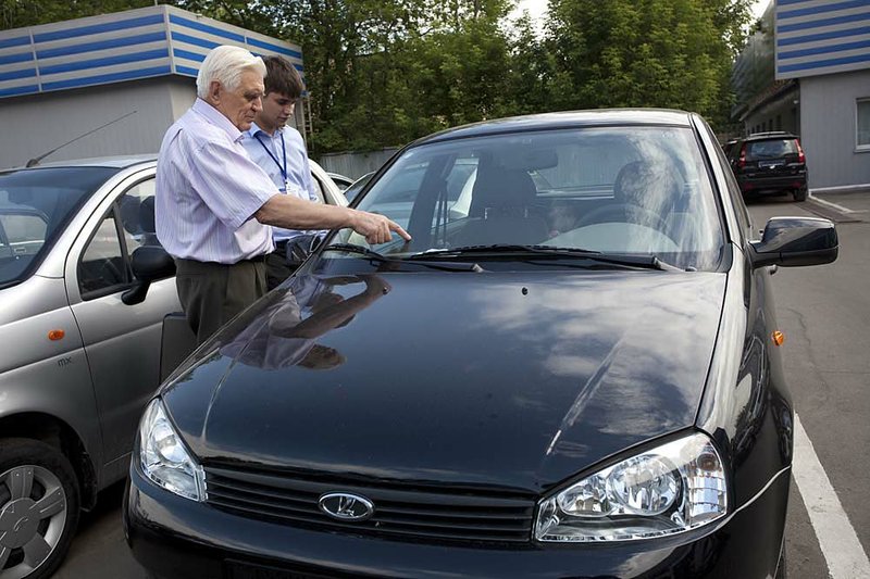  A customer inspects a new Lada Kalina vehicle for sale at an OAO AvtoVAZ dealership in Moscow, Russia, on Friday, June 24, 2011. Russia's OAO AvtoVAZ  aims to produce and sell about 700,000 cars and "auto complects" in 2011. Photographer: Alexander Zemlianichenko Jr./Bloomberg