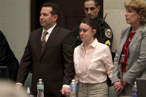 Casey Anthony holds hands with her defense attorneys, Jose Baez, left, and Dorothy Clay Sims, as they listen to the verdict at the Orange County Courthouse in Orlando, Fla., on Tuesday, July 5, 2011. The jury acquitted Anthony of murdering her daughter, Caylee.