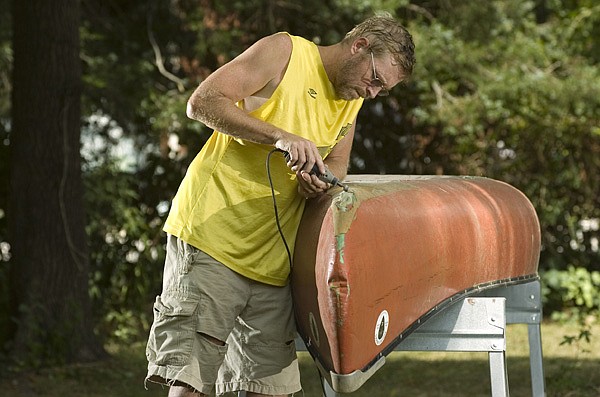 Wayne Ramsey of Lou’s Canoe and Kayak Repair in Fayetteville cuts the skid plate off of a canoe Tuesday as the temperature nears 100 degrees.