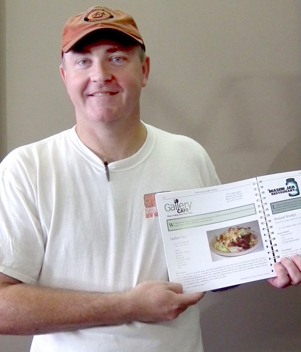 Gallery Cafe owner Stacy Brooks shows the newly-released cook book, “Taste of Main Street America.”
