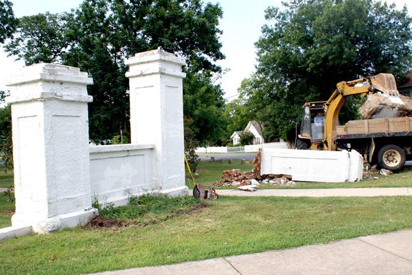 A backhoe loads a huge chunk that was part of one of the entrance pillars at Captain Field Kindley Park in Gravette. The pillars are in the process of being replaced.

