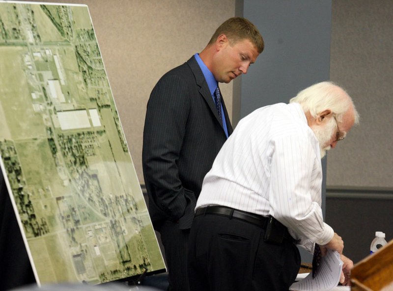 Former Arkansas State Police Trooper Andrew Rhew (left) confers with his attorney, Robert Newcomb, before a State Police Commission hearing in Little Rock on Thursday. 