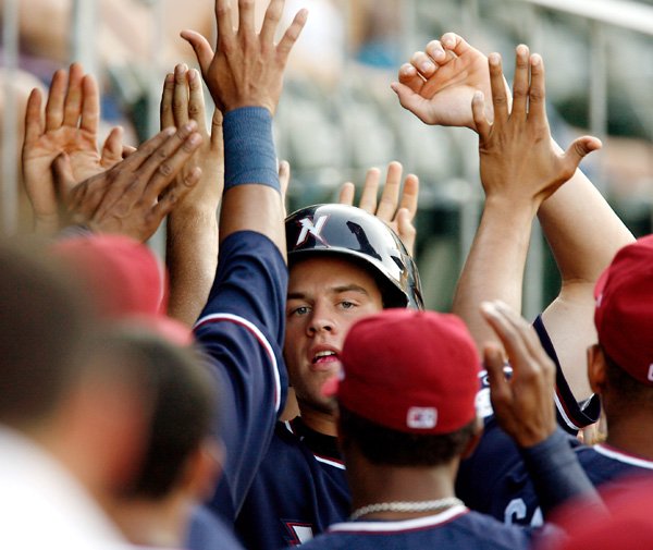 NWA Natural Wil Myers, center, is congratulated by teammates on his return to the dugout after scoring in the first inning against Tulsa on Tuesday at Arvest Ballpark in Springdale.