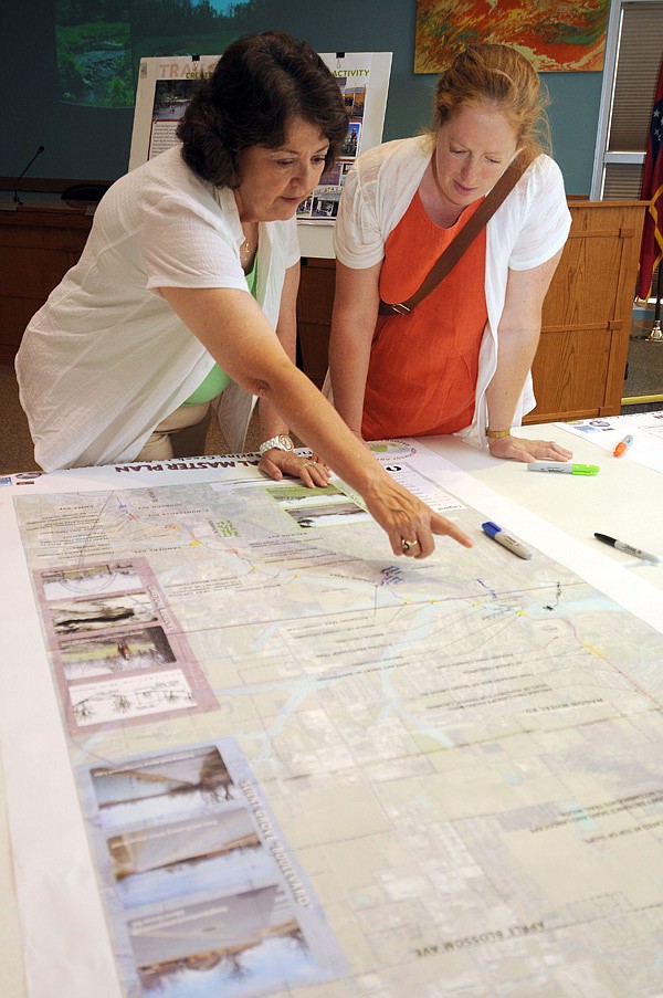 Sarah King, right, talks with Patsy Christie, director of planning and community development with the city of Springdale, about the proposed route of the Razorback Greenway at a public input meeting Monday at Springdale City Hall. Many residents came to the meeting to offer their insights and express interest in the project.