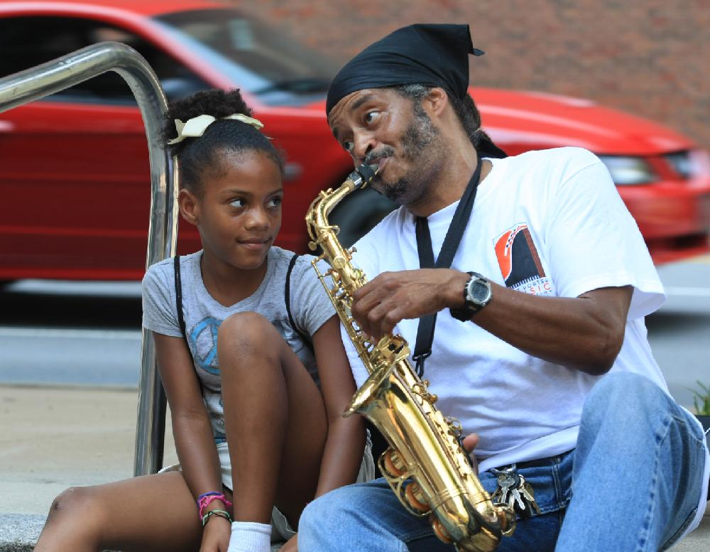 Arkansas Democrat-Gazette/fSTATON BREIDENTHAL 8/2/11
Shakira (cq) Childers (left), 11, listens to Gerald Johnson play saxophone Tuesday in the Metropolitan Bank building plaza in downtown Little Rock. The event was organized by, Art Porter Music Education Inc., as part of events this week to celebrate the musician's 50th birthday on Aug. 3.