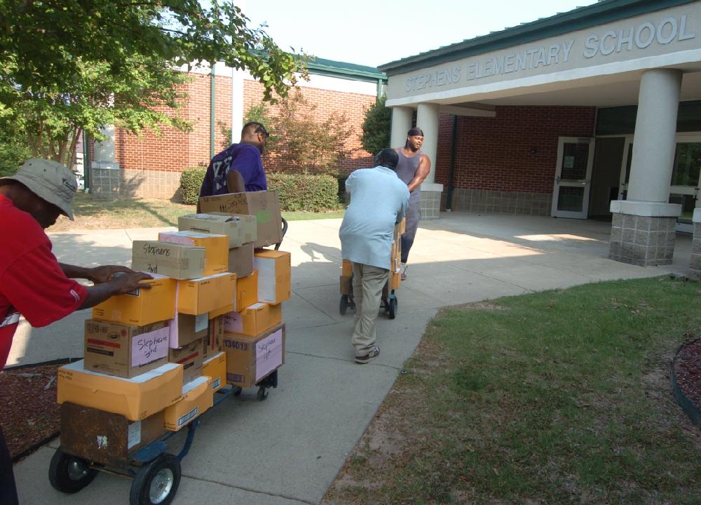 Arkansas Democrat-Gazette/STEVE KEESEE 7/28/11 Little Rock School District employees move carts with boxes of school supplies Thursday that the Junior League of Little Rock have donated to students in need at Little Rock School District's Stephens Elementary, one of six district schools receiving the items . The JLLR program called Stuff the Bus began five years ago with the goal of adding one LRSD elementary a year, Romine Elementary was added this year.
