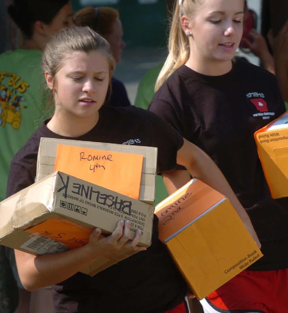 Arkansas Democrat-Gazette/STEVE KEESEE 7/28/11 Volunteers, Lexie Sadler (left) and Jayme Holland, members of the Mount St. Mary Academy cheerleading squad , help unload a truck Thursday filled with school supplies that the Junior League of Little Rock is donating to students in need at Little Rock School District's Romine Elementary, one of six district schools receiving the items . The JLLR program called Stuff the Bus began five years ago with the goal of adding one LRSD elementary a year.