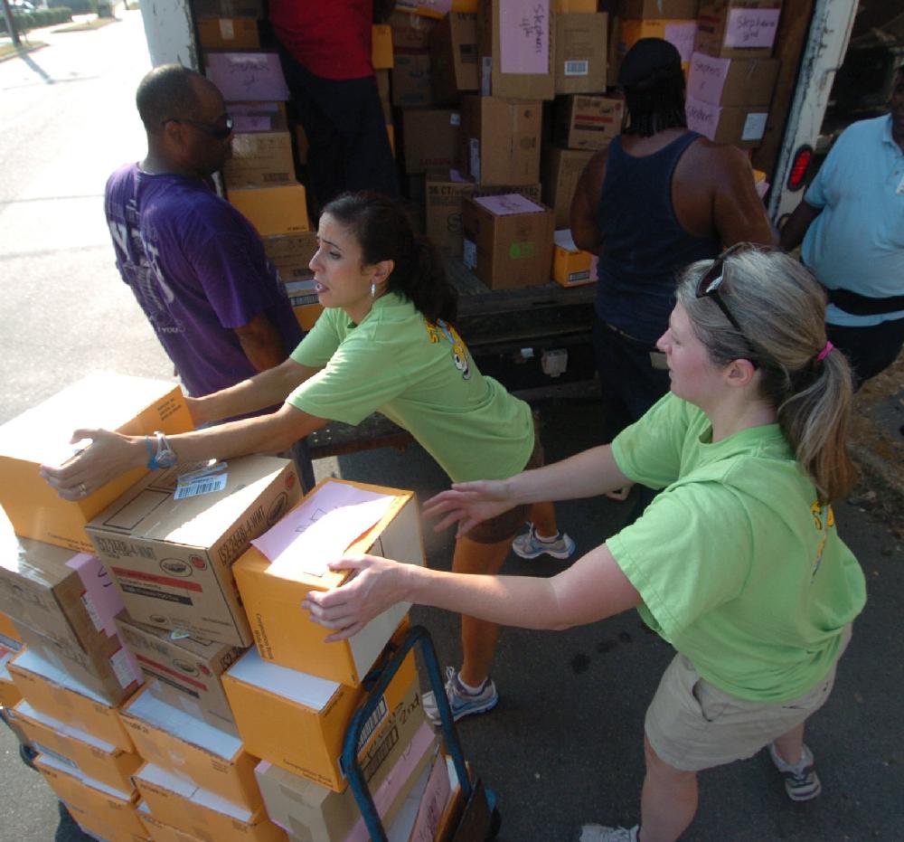 Arkansas Democrat-Gazette/STEVE KEESEE 7/28/11 Volunteers, Kay Payne (left) and Ashley Zimmer from the Junior League of Little Rock help Little Rock School District employees load boxed school supplies into one of three trucks used Thursday to deliver the donated items for students to six district elementary schools. The JLLR program called Stuff the Bus began five years ago with the goal of adding one LRSD elementary a year.