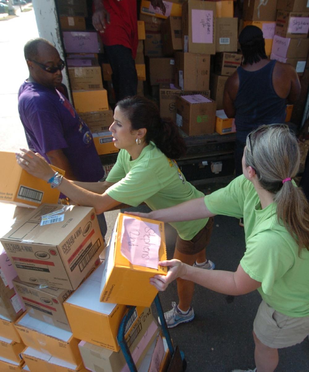 Arkansas Democrat-Gazette/STEVE KEESEE 7/28/11 Volunteers, Kay Payne (center) and Ashley Zimmer from the Junior League of Little Rock help Little Rock School District employees, Kem Austin (left), load boxed school supplies into one of three trucks used Thursday to deliver the donated items for students to six district elementary schools. The JLLR program called Stuff the Bus began five years ago with the goal of adding one LRSD elementary a year.