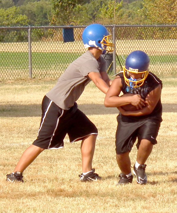 Victor Urquidi and Alan Castaneda practiced handing off the ball during the Decatur Football Team's practice on Monday. Practice with full pads is scheduled to begin Thursday, and the first game of the season will be on Sept. 3.