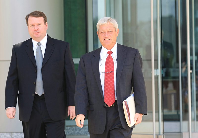 Kevin Harold Lewis (left) leaves the federal courthouse in Little Rock with attorney Tim Dudley after pleading guilty. 