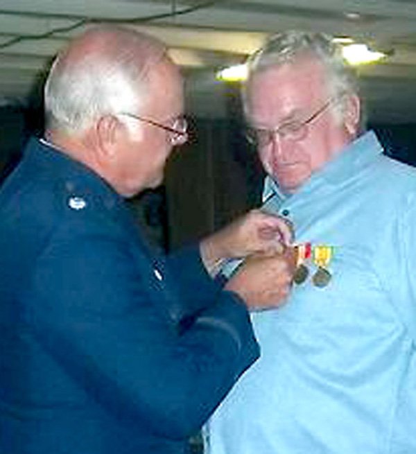 Lt. Col Gray pinned service medals on Gravette resident John Roquemore at a July 9 ceremony.
