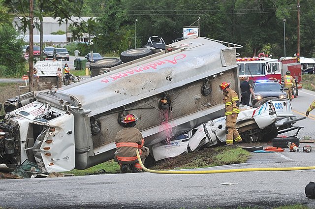 Diesel fuel leaks from a tanker that overturned on top of a Cox Communications pickup truck on Thursday morning at Arkansas 12 and Dream Valley Road in Rogers. 