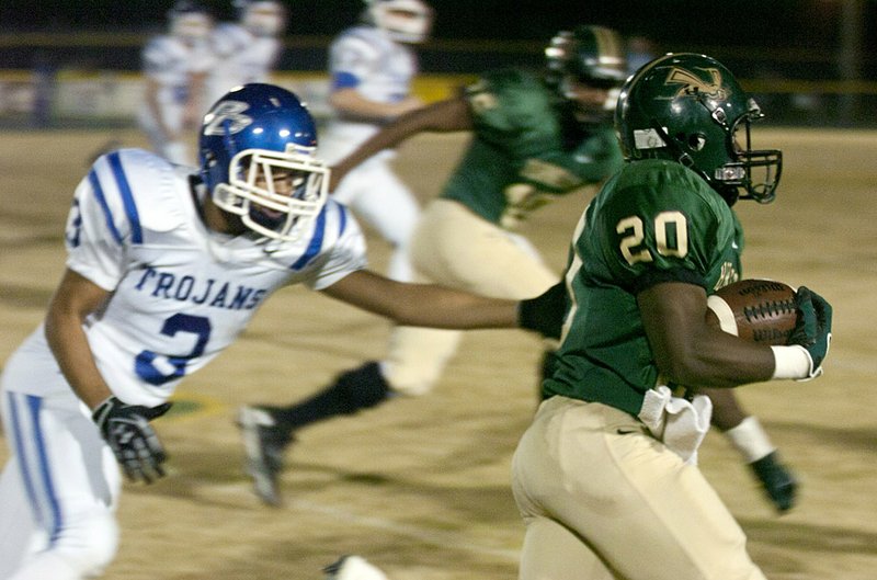  Staff photo by Eric J. Shelton
Mineral Springs High School's running back Rashad Williams dodges a Trojan defender during their game Friday night at Hornet Stadium. 
