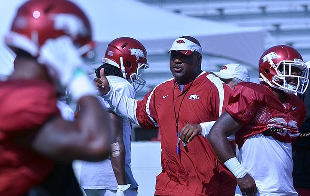 University of Arkansas assistant coach Reggie Johnson works with the team during practice Monday afternoon at Razorback Stadium in Fayetteville.