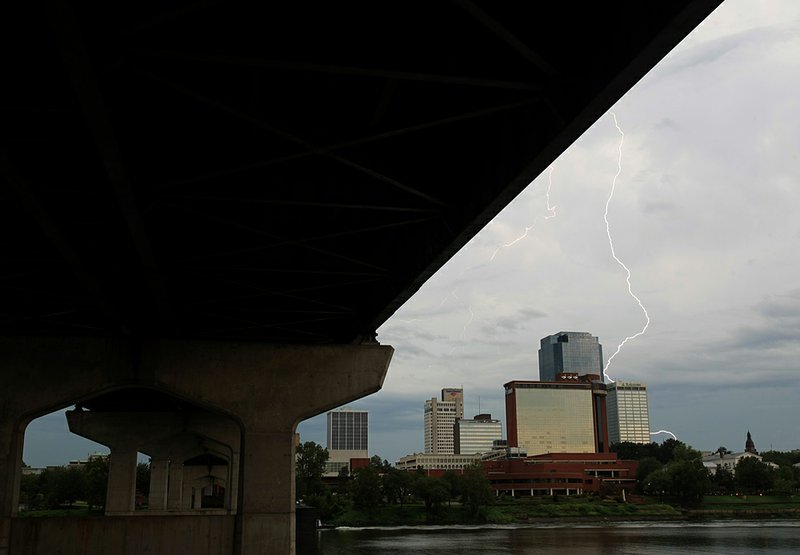 FILE - A bolt of lightning strikes behind the Little Rock skyline during a series of morning thunderstorms in 2011.