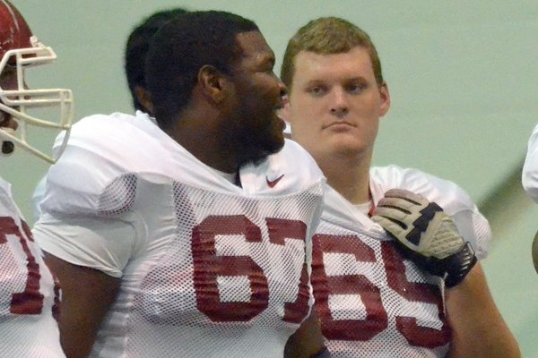   University of Arkansas offensive linemen Alvin Bailey (left) and Mitch Smothers get ready to run drills during practice at the University of Arkansas.