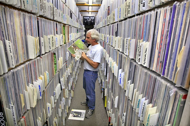 Bill Eginton prices and files vinyl records at Arkansas Record and CD Exchange in North Little Rock. Eginton has seen sales of new and used records grow 20 percent in the past two years. 