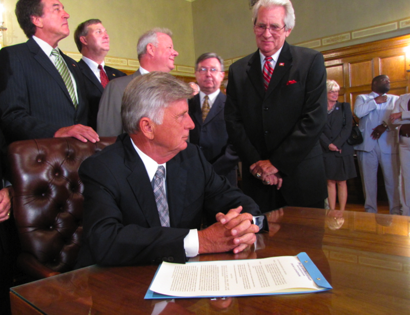 Gov. Mike Beebe listens to a supporter in the audience shortly after signing a proclamation setting a Nov. 8 special election for a highway bond program.