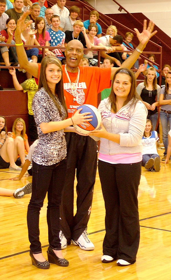 Gentry High School students Suzie Sikes and Kendra Pettit are pictured with Harlem Swish Captain "Magic" Valentino Willis at an anti-drug school assembly on Aug. 24. Willis encouraged students to respect parents and teachers and to refuse alcohol and drugs.
