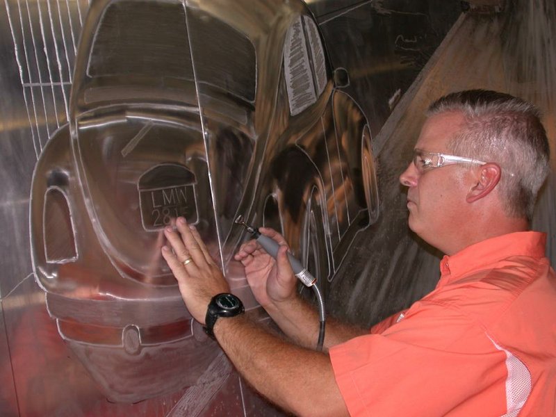 Arkansas Democrat Gazette/KENNETH HEARD -- 09/01/2011 -- Danny West engraves details of a Volkswagen on a 10x20-foot aluminum sheet that replicates the cover of The Beatles Abbey Road album. The display will be unveiled during a Sept. 18 ceremony in Walnut Ridge to commemorate the group's 1964 visit to the town's airport 
