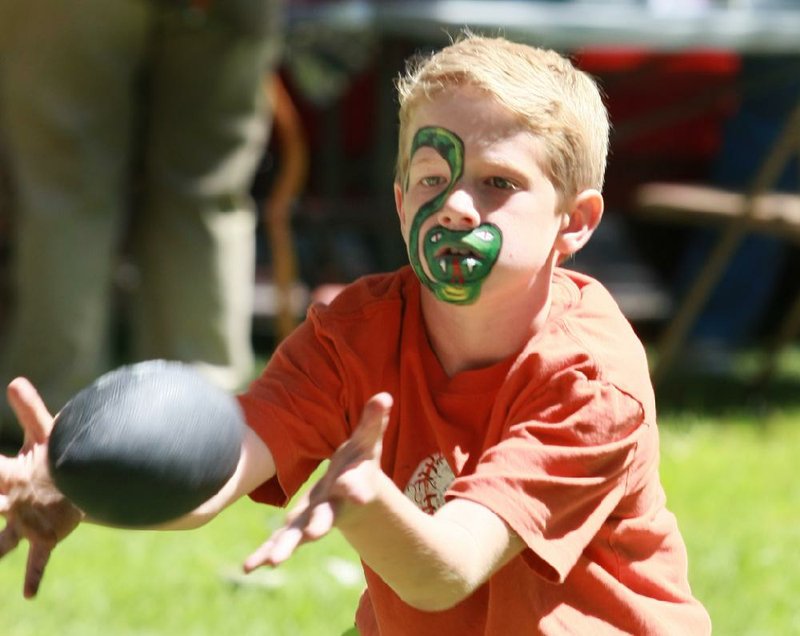Drew Warren, 8, of Benton catches a football at the Central Arkansas Labor Council Labor Day Picnic on the grounds of the Governor’s Mansion in Little Rock on Monday. 
