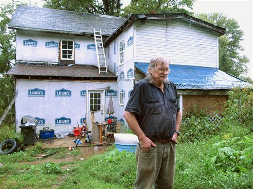 Charles Richardson Jr. stands in the rain outside a rural home near Morgantown, W.Va., Tuesday Sept. 6, 2011. Richardson's son and four other family members were shot to death at this house on Monday Sept. 5, 2011.