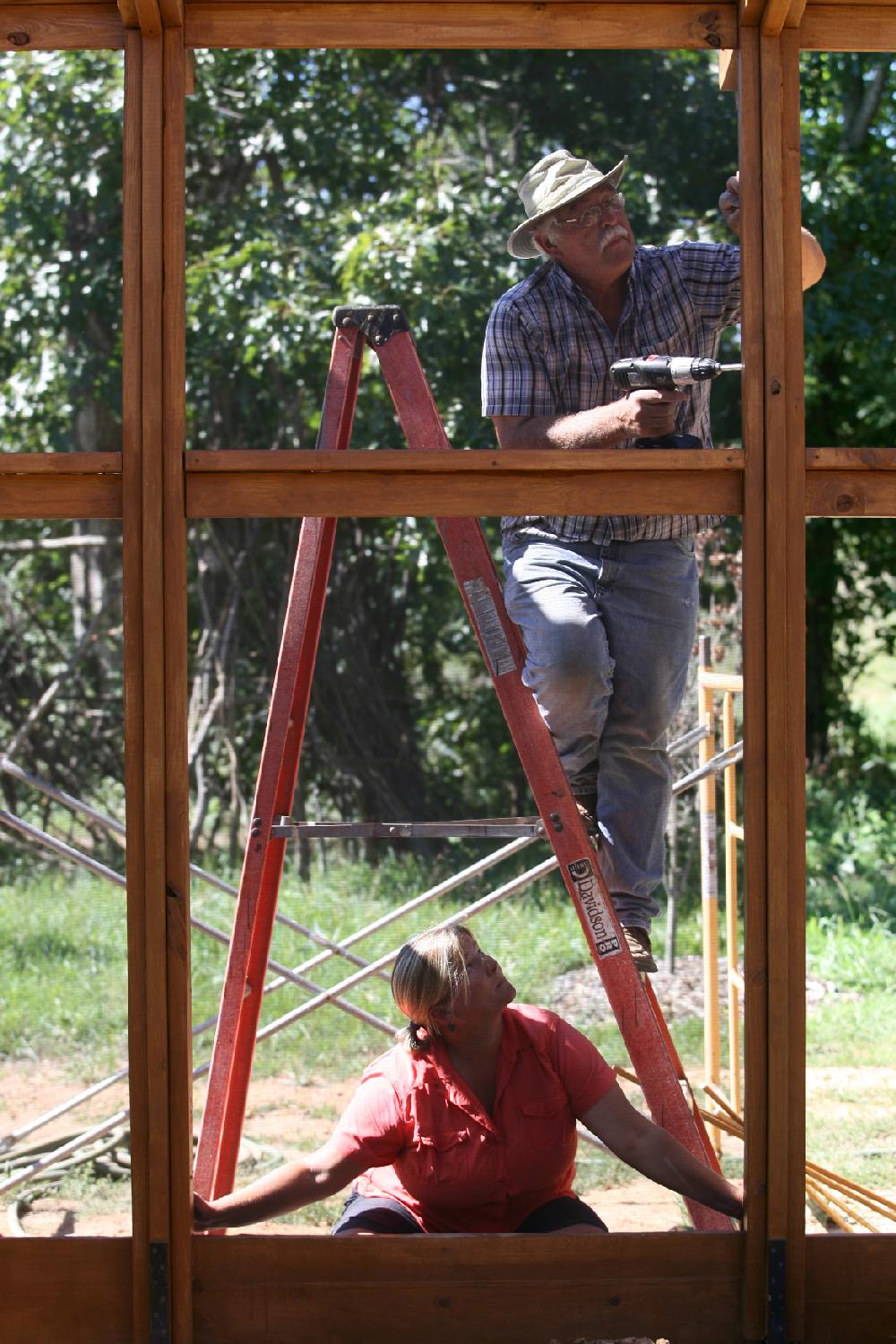 Arkansas Democrat-Gazette/RYAN MCGEENEY --09-06-2011-- 
Botanical Garden of the Ozarks gardner Holly Shields, bottom, and director of operations Gerald Klingaman, top, fit a portion of the garden's new Butterfly House with mesh screening Tuesday morning in Fayetteville. The house is scheduled to open to the public Sept. 19.