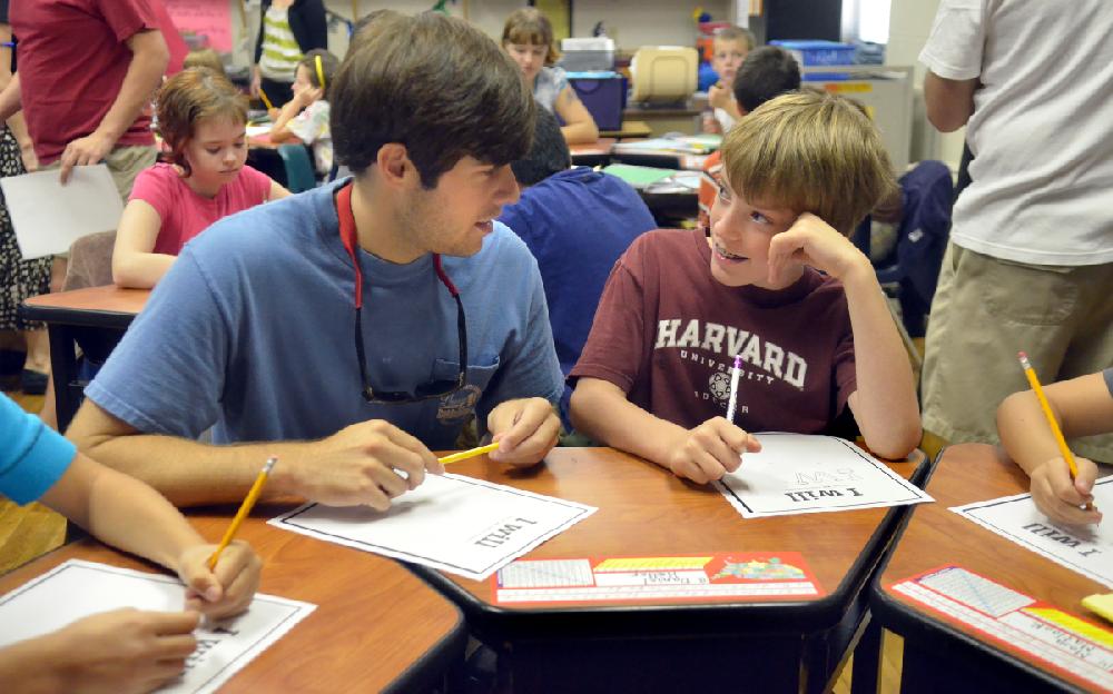 Arkansas Democrat-Gazette/MICHAEL WOODS  --09/06/11-- University of Arkansas Volunteer Action Center volunteer, Timothy Tucker , junior from Wynne, talks with Leverett 5th grader Daniel Hatter Tuesday afternoon while he and other volunteers talk to  the Leverett 5th graders about remembering the events and people of 9/11/01.  The volunteers talked about the importance of the Bill of Rights and did an exercise with the students to see what they would be willing to do to help volunteer their time for their family and community.
