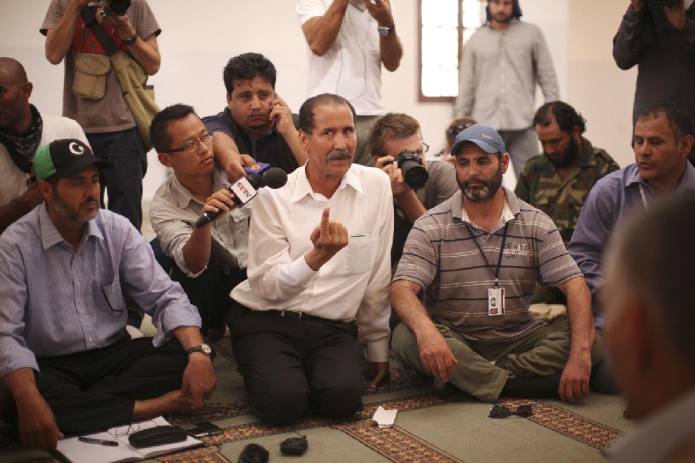 Abdalla Kenshil, chief rebel negotiator, centre, speaks to tribal elders during negotiations in a mosque at a checkpoint between Tarhouna and Bani Walid, Tuesday, Sept. 6, 2011. Moammar Gadhafi is determined to fight his way back to power, the toppled dictator's spokesman said Tuesday, but a large convoy of his soldiers has apparently deserted, crossing the Libyan desert into neighboring Niger.(AP Photo/Alexandre Meneghini)