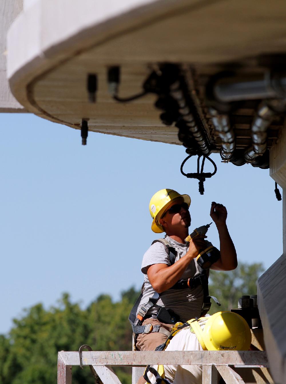 Arkansas Democrat-Gazette --9/6/11--
Brad Atkinson and Quinton Richter, with Koontz Electric, install over 600 new LED lights underneath the Two Rivers Park Bridge on Tuesday. The bridge will be closed for public use until the weekend while work continues.