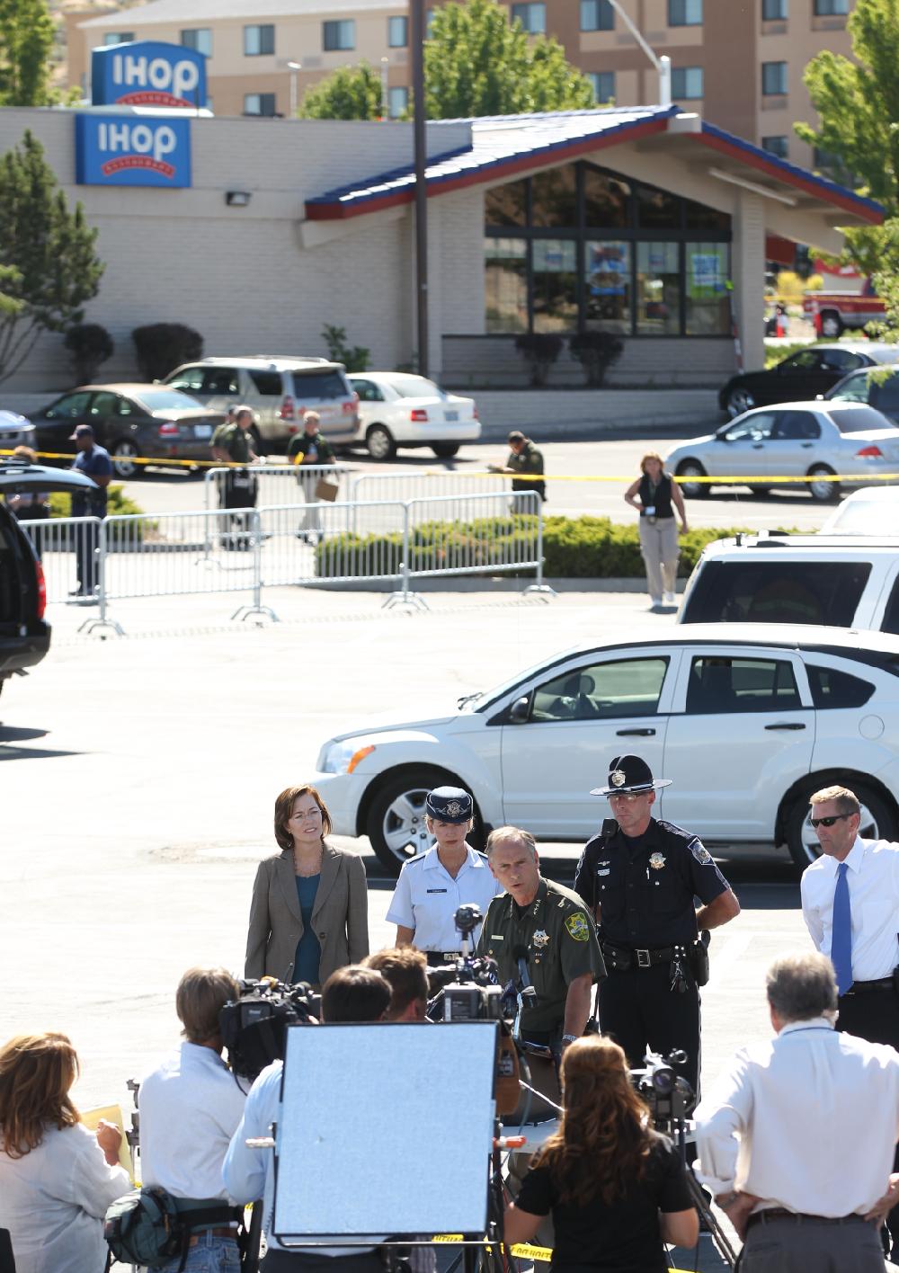 Carson City Sheriff Ken Furlong, center, holds a news conference outside the IHOP restaurant in Carson City, Nev., on Tuesday, Sept. 6, 2011, after a gunman opened fire with an AK-47, killing three and injuring six. (AP Photo/Cathleen Allison)
