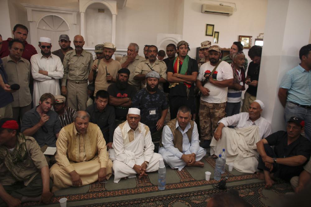 Tribal elders, bottom, speak to Abdalla Kenshil, chief rebel negotiator, not in the picture, during negotiations in a mosque at a checkpoint between Tarhouna and Bani Walid, Tuesday, Sept. 6, 2011. Moammar Gadhafi is determined to fight his way back to power, the toppled dictator's spokesman said Tuesday, but a large convoy of his soldiers has apparently deserted, crossing the Libyan desert into neighboring Niger.(AP Photo/Alexandre Meneghini)