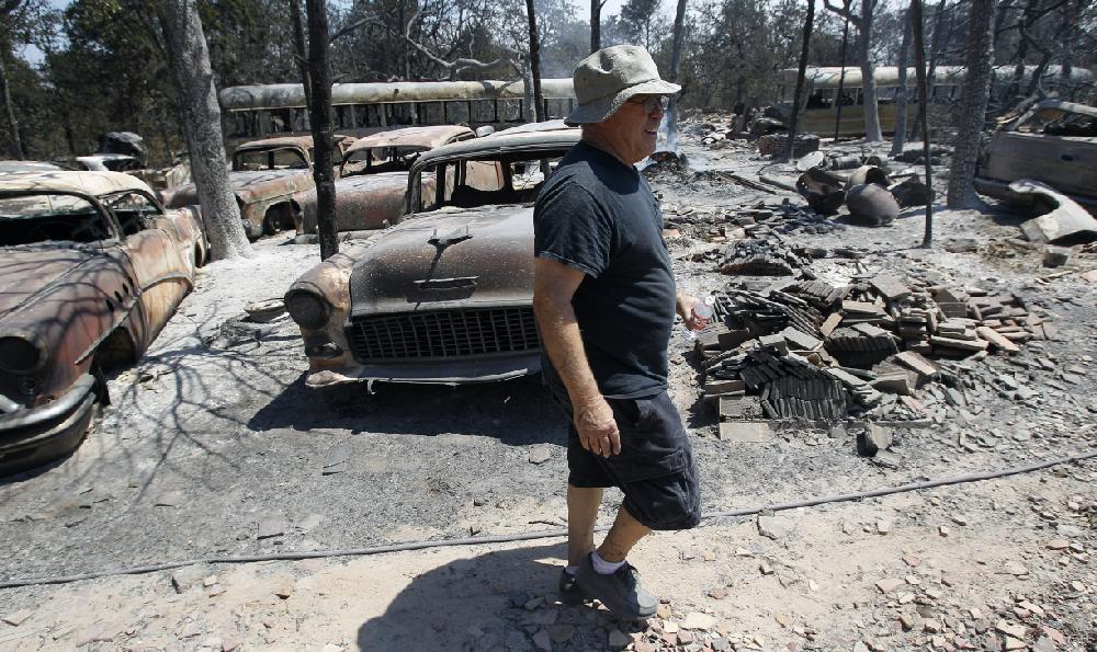 Car collector John Chapman surveys the losses at his home, Tuesday, Sept. 6, 2011, in Bastrop, Texas. Chapman lost more than 175 cars to the wildfires. More than 1,000 homes have been destroyed in at least 57 wildfires across rain-starved Texas, most of them in one devastating blaze near Austin that is still raging out of control, officials said Tuesday. (AP Photo/Eric Gay)
