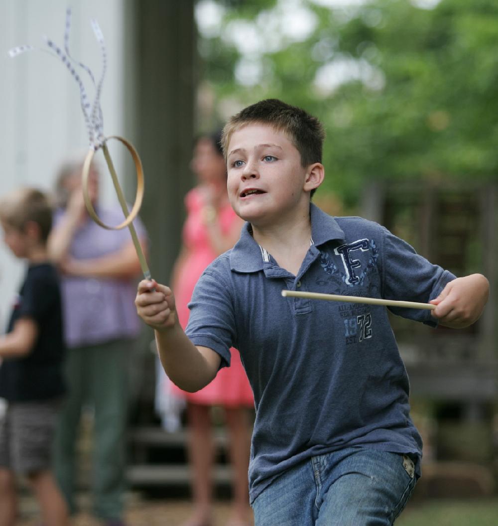 Arkansas Democrat-Gazette/RYAN MCGEENEY --08-04-2011-- 
Eli Denham, 8, of Fayetteville, tries to catch a wooden loop in a game of "graces"  Thursday morning at the Shiloh Museum of Ozark History in Springdale. Denham was among a group of about a half-dozen young people participating in a toy-making workshop at the museum.