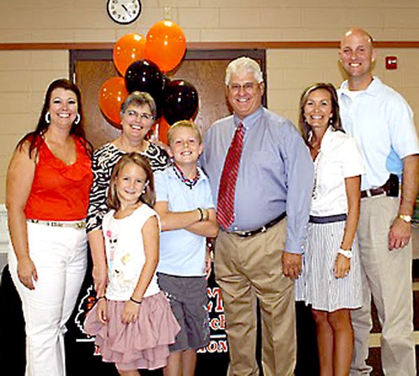 Mitchell Wilber, center, surrounded by family, including his wife Jane on his right, was honored upon his retirement from the Gravette Public School system. Others, from the left, are his daughter, Cory Wilber; grandchildren, Henley and Rayner; and his daughter Camron and her husband Phil Whitehead.