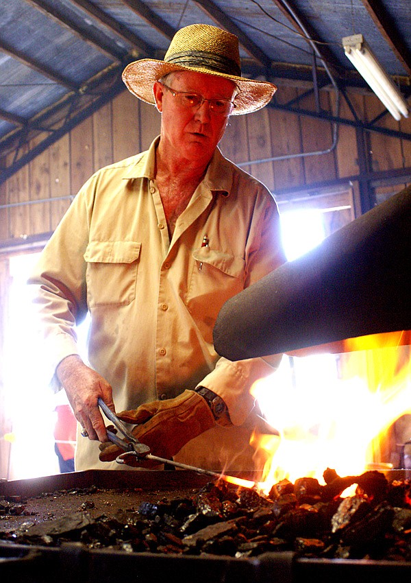 Steve Low, of Gentry, heats a piece of iron in the forge before shaping it on the anvil during a Friday demonstration of the old art of blacksmithng.
