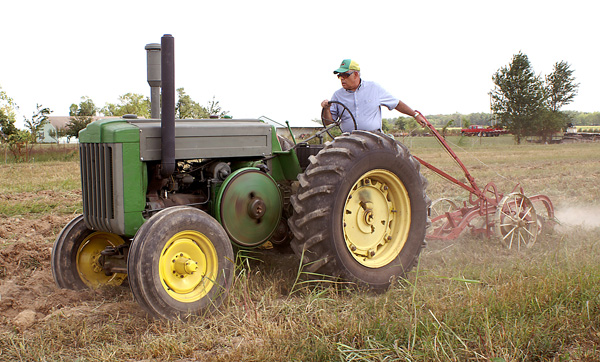 Dave Shoop drives a 1948 John Deere "D" tractor and operates an antique 2-bottom pull plow at the Tired Iron Show on Friday.