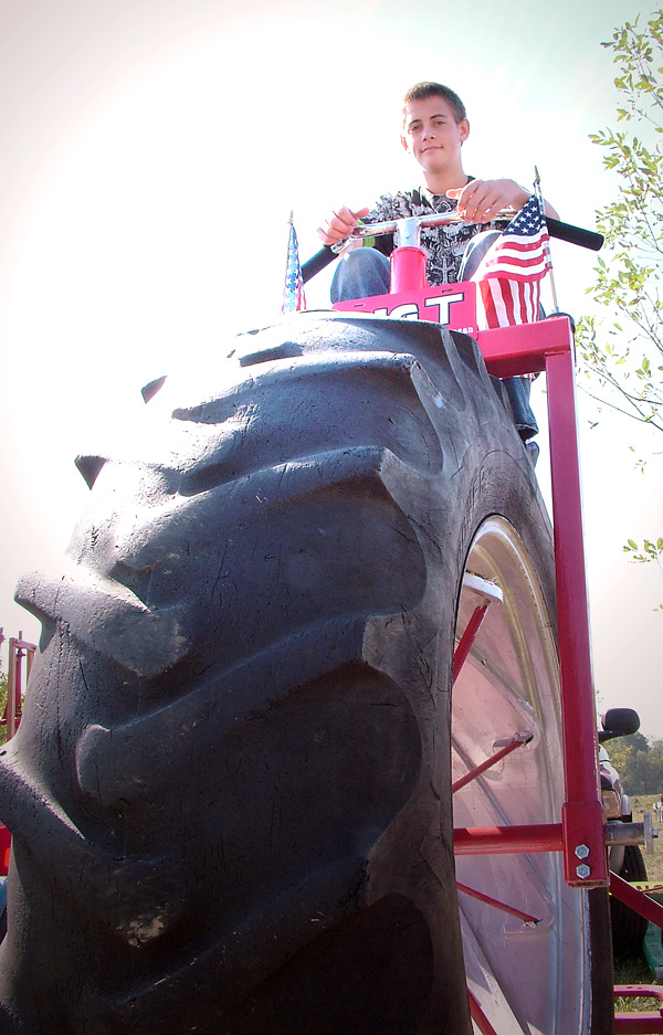 Dakota McMillan, of Rogers, sits atop Big T, a tricycle built with 15-inch rear tires and a 38-inch tractor tire on the front.