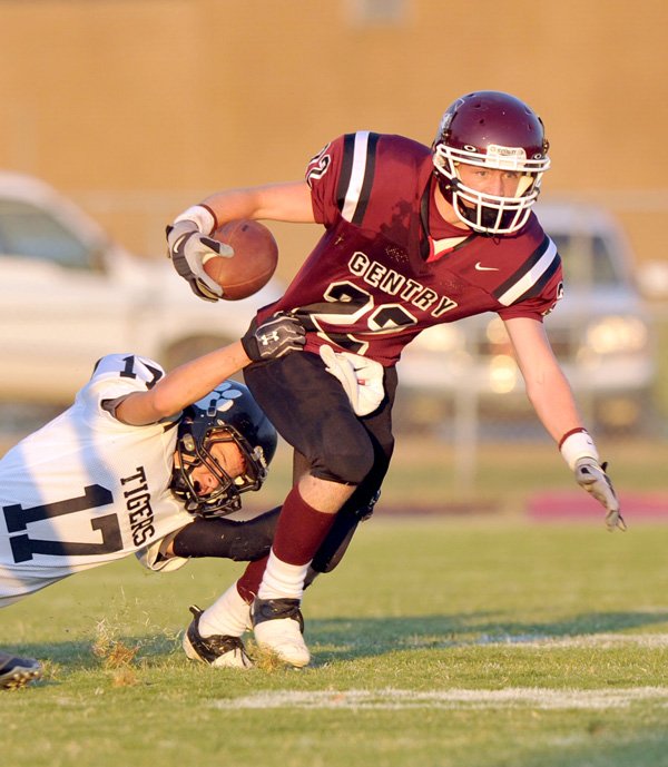 Charleston defender Seth McCann tries to drag down Gentry running back Jarod Cousins in the first half of Friday night's game in Gentry.

