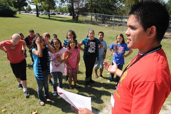 Ryan Quintana, right, fifth-grade science teacher, instructs students Friday in an outdoor “total physical response” display of lessons they have learned in the classroom at Bonnie Grimes Elementary School in Rogers. The Rogers School District recruited Quintana last year at a job fair in New Mexico.
