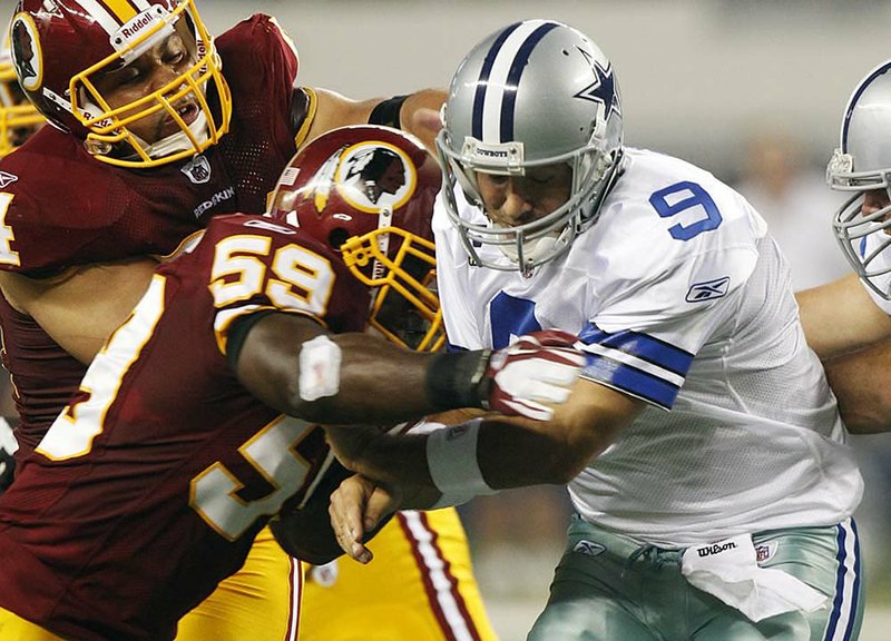 Dallas Cowboys quarterback Tony Romo (right) takes a hit from Washington Redskins inside linebacker London Fletcher during Monday’s game in Arlington, Texas. Romo, playing a week after fracturing a rib and puncturing a lung, threw for 255 yards with one interception. 