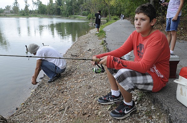 Johnathan Pineda, 12, of Springdale, fishes Sunday at Lake Springdale with his family. The Springdale Water and Sewer Commission is considering giving the lake and area around it to the city for an official park.